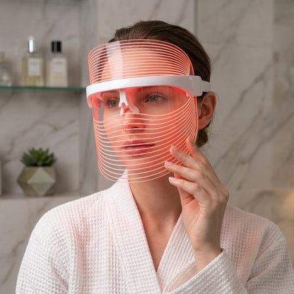 Woman wearing byTheia 7 Colour LED face mask at home, 10 minute hands-free LED light therapy treatment Canada