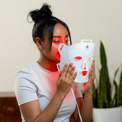 Woman wearing byTheia Advanced LED Facial Mask BTFM03 secured on face — full-face red light therapy coverage with flexible medical-grade silicone fit