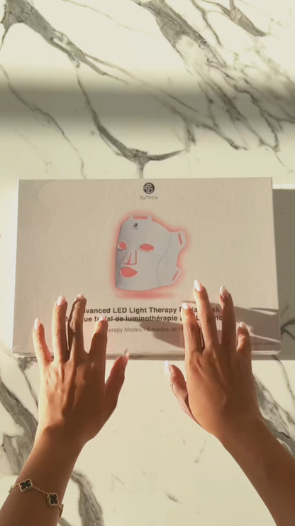 Unboxing video: hands opening the byTheia LED face mask box on a marble counter.